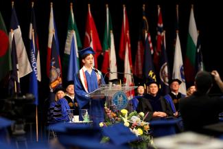 Mostafa Mubarak standing at podium delivering speech at UK Commencement on May 8. 