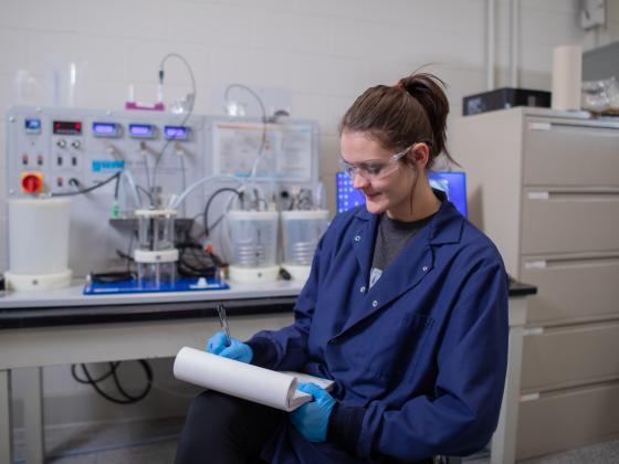 Woman in front of chemical engineering equipment