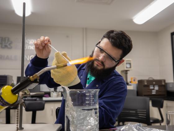 Student in Materials Science Lab with blow torch and melting glass